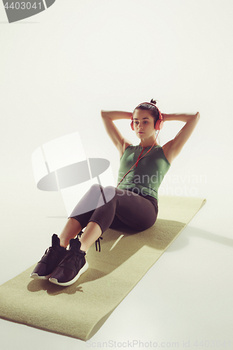 Image of Front view of a young woman stretching body in gymnastics class.