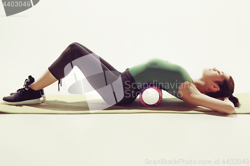 Image of Front view of a young woman stretching body in gymnastics class.