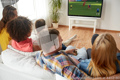 Image of friends watching soccer game on tv at home