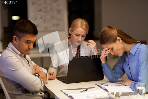 Image of business team with laptop working late at office