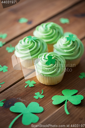 Image of green cupcakes with shamrock decorations on table