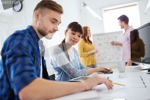 Image of creative team with blueprint at office