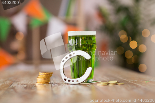 Image of glass of green beer, horseshoe and gold coins