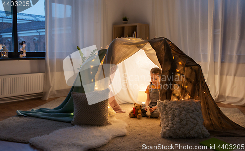 Image of little girl with toys in kids tent at home