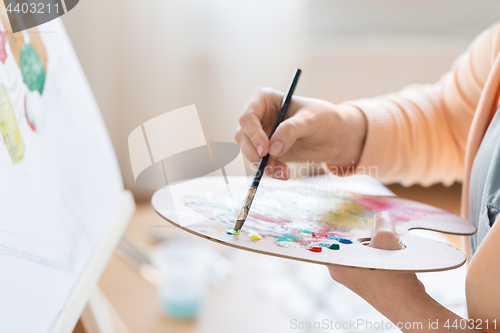 Image of artist with palette painting at art studio