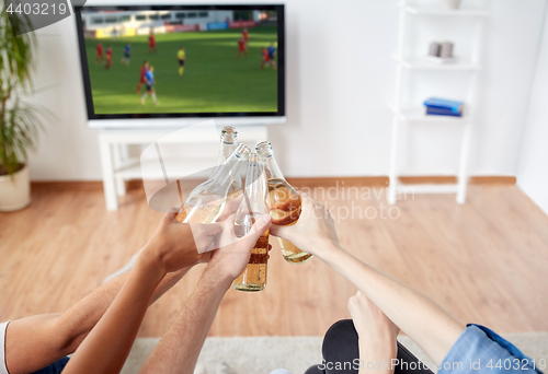 Image of friends with beer watching football or soccer game