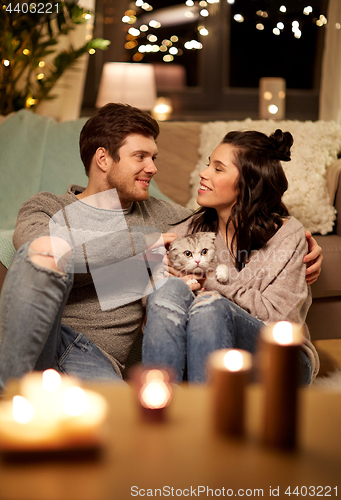 Image of happy couple with cat at home