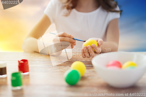 Image of close up of girl coloring easter eggs 