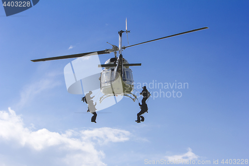 Image of Special forces in helicopter with blue sky on background