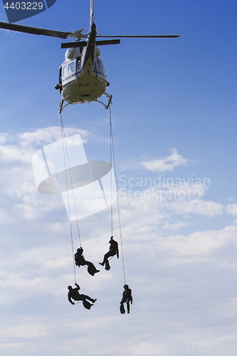 Image of Special forces in helicopter with blue sky on background