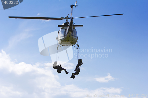 Image of Special forces in helicopter with blue sky on background