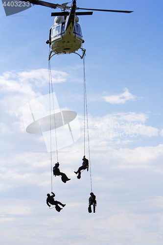 Image of Special forces in helicopter with blue sky on background