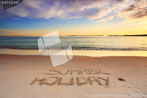 Image of Summer Holiday etched into the sand of beach