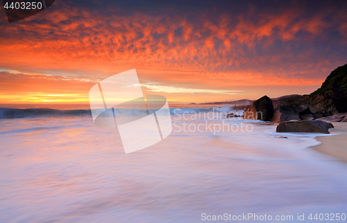 Image of Dramatic red skies and frothy white waves beaches