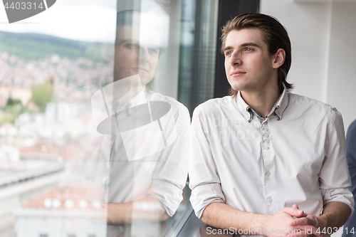 Image of young businessman in startup office by the window