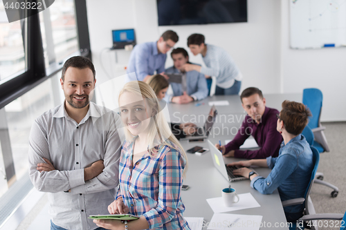 Image of Two Business People Working With Tablet in office