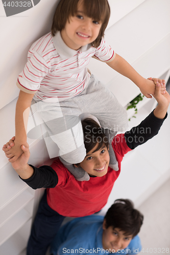 Image of young boys posing line up piggyback top view