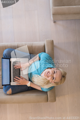 Image of Young woman using laptop at home top view