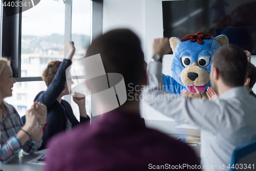 Image of boss dresed as bear having fun with business people in trendy of