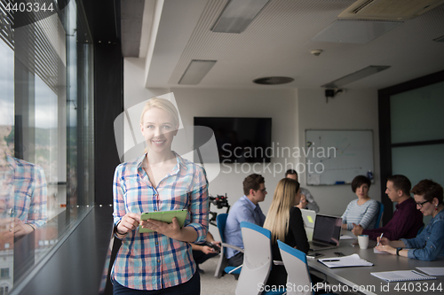 Image of Pretty Businesswoman Using Tablet In Office Building by window