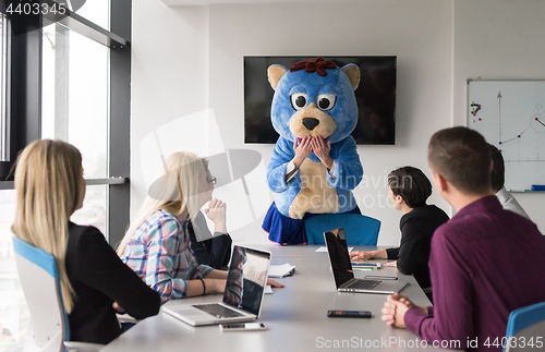 Image of boss dresed as bear having fun with business people in trendy of