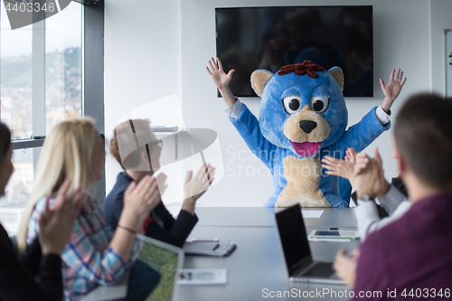 Image of boss dresed as bear having fun with business people in trendy of