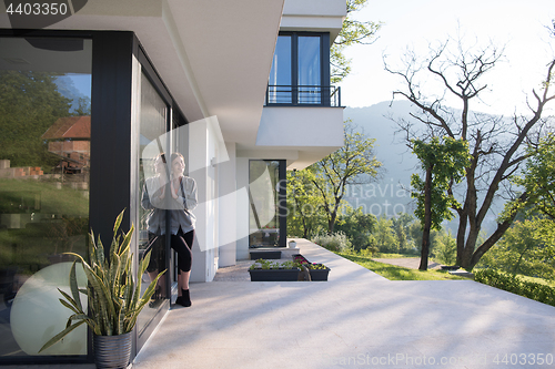 Image of woman in front of her luxury home villa