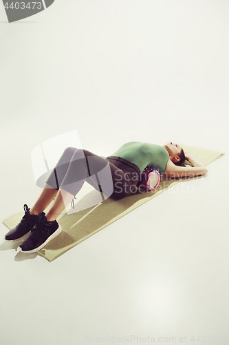 Image of Front view of a young woman stretching body in gymnastics class.