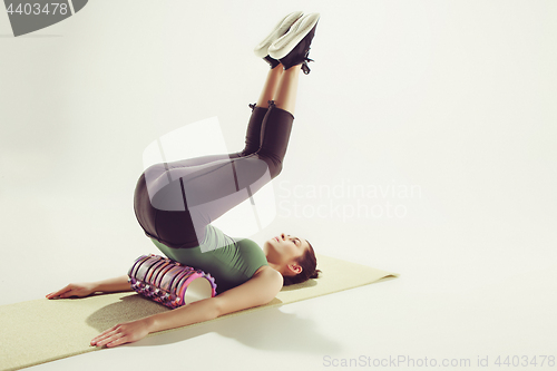 Image of Front view of a young woman stretching body in gymnastics class.