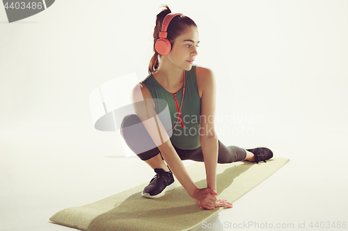 Image of Front view of a young woman stretching body in gymnastics class.