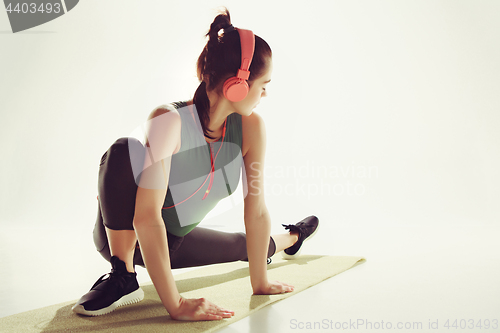 Image of Front view of a young woman stretching body in gymnastics class.