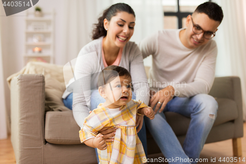 Image of happy family with baby daughter at home