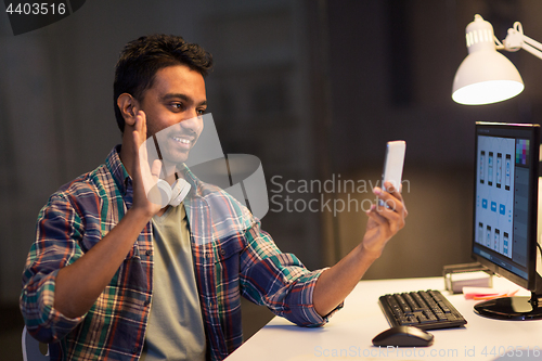 Image of man with smartphone having video call at office