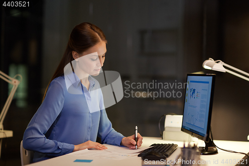 Image of businesswoman at computer working at night office