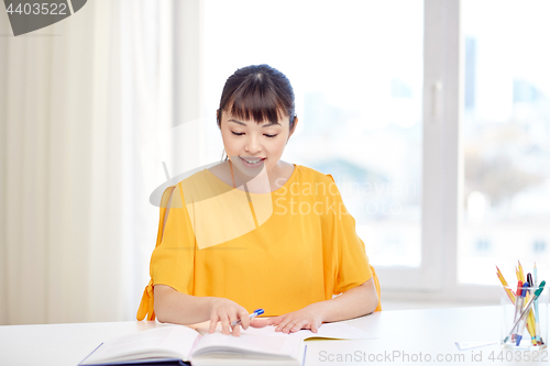 Image of happy asian young woman student learning at home