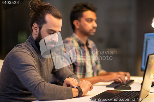 Image of creative man with smartwatch working at office