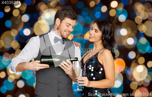 Image of happy couple with champagne and glass at party