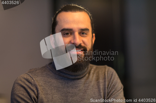 Image of smiling middle eastern man in polo neck sweater