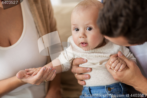 Image of close up of happy family with baby at home