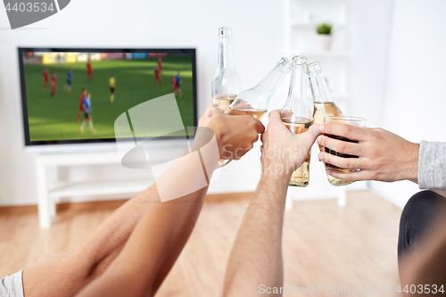 Image of friends with beer watching football or soccer game