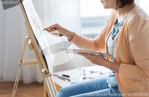 Image of artist with palette knife painting at art studio