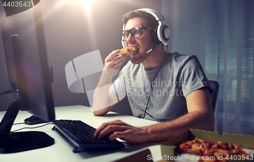 Image of man in headset playing computer video game at home