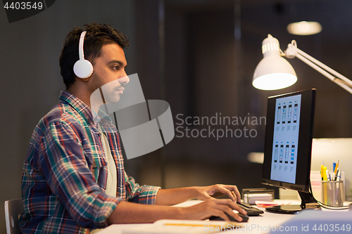 Image of creative man in headphones with computer at office