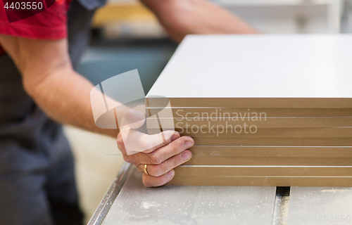 Image of close up of carpenter with boards at factory