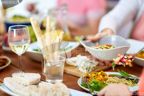 Image of people putting salad on plate with food