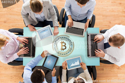 Image of business team with computers and bitcoin hologram