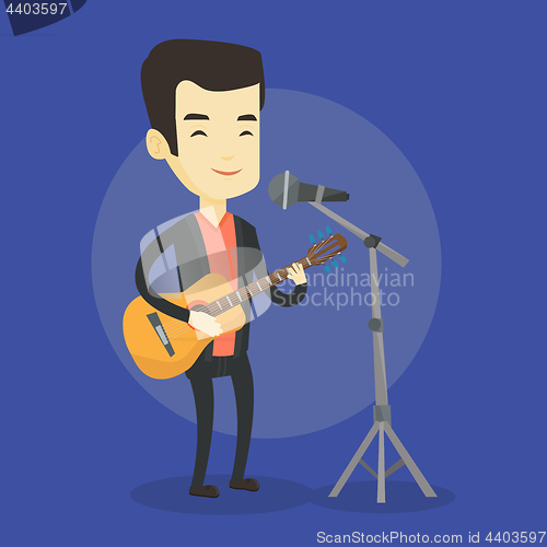 Image of Man singing in microphone and playing guitar.