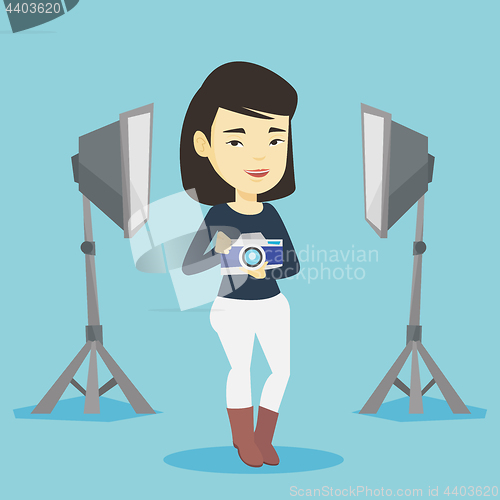 Image of Photographer with camera in photo studio.