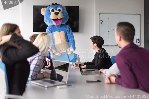 Image of boss dresed as bear having fun with business people in trendy of