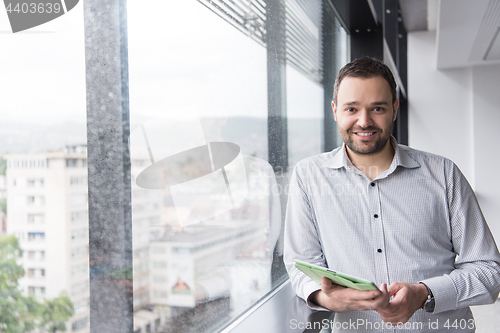 Image of Businessman Using Tablet In Office Building by window